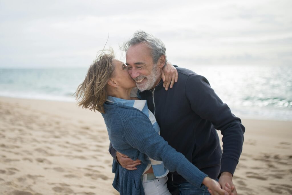 A mature couple enjoying a romantic moment on a Portuguese beach, symbolizing love and togetherness.
